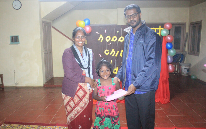 Fr. John Wilson Gifting Rain Coat to Kovilmedu Night School Children